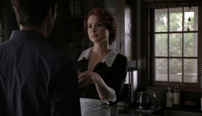 A man and woman standing next to each other in a kitchen.