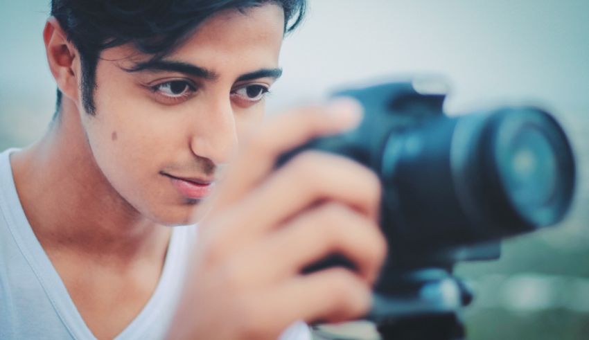 A young man is taking a picture with a camera.