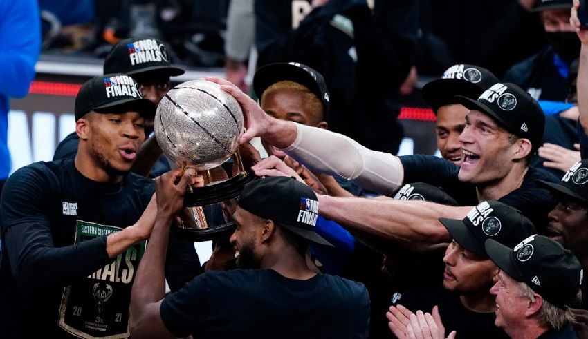 A group of basketball players holding up a trophy.