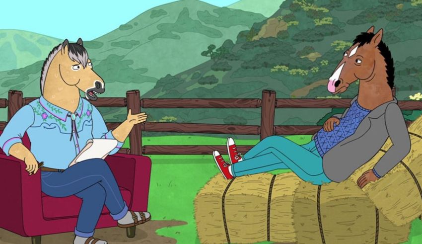 A man and a horse talking on a couch in front of hay bales.