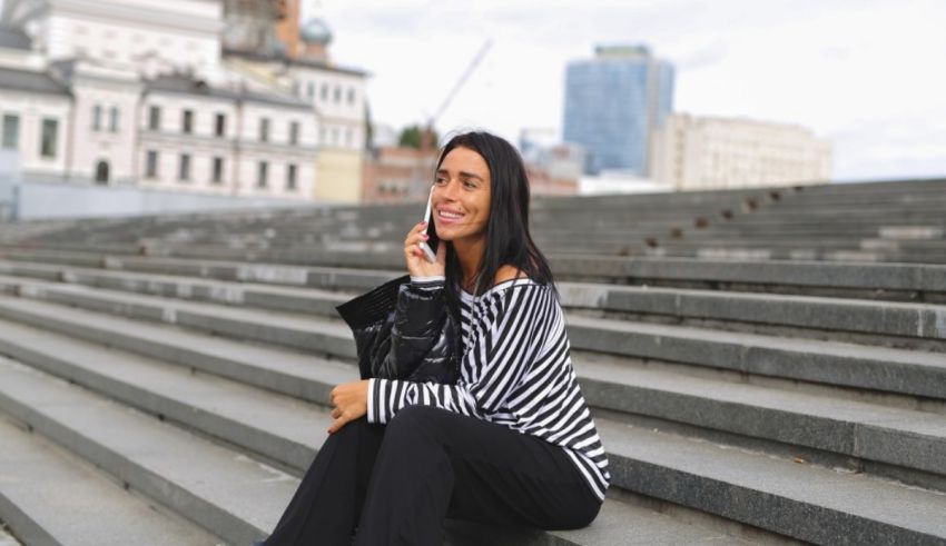 A woman sitting on steps talking on the phone.