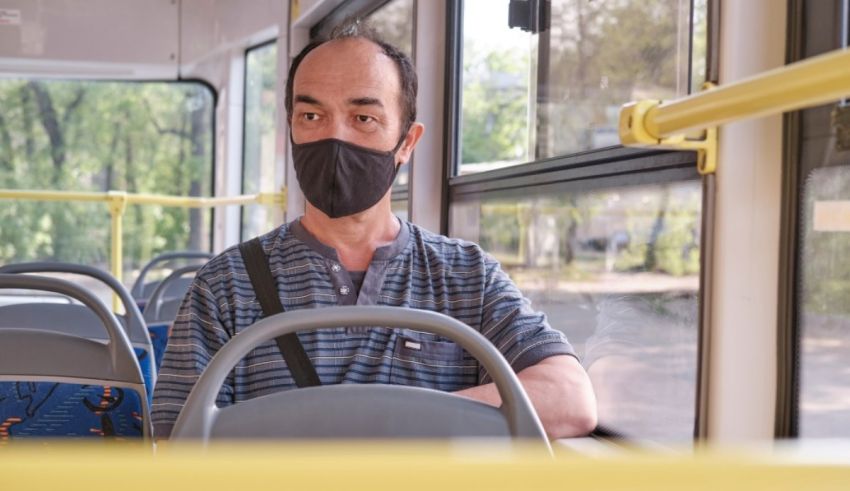 A man wearing a face mask on a bus.