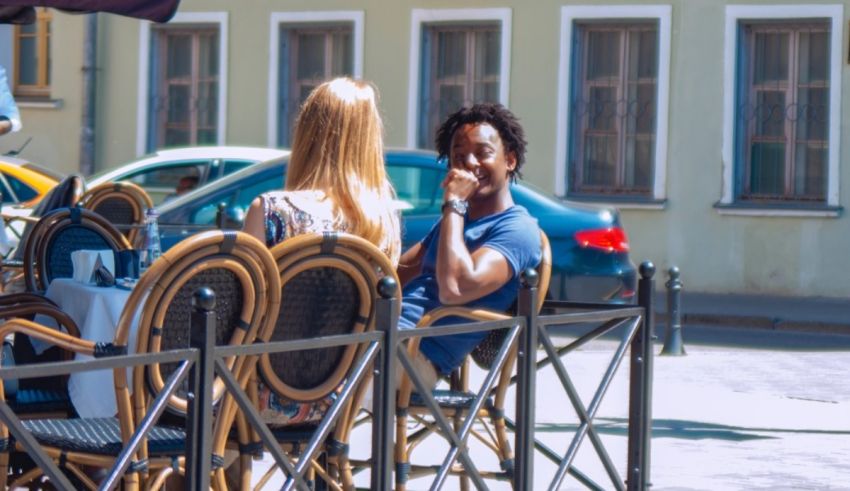 Two people sitting at a table in an outdoor cafe.