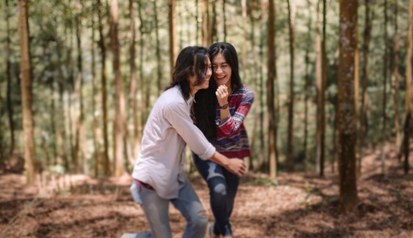 Two asian women hugging in a wooded area.