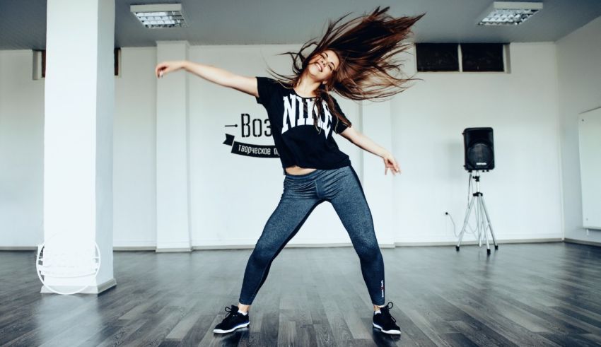 A young woman is dancing in a dance studio.