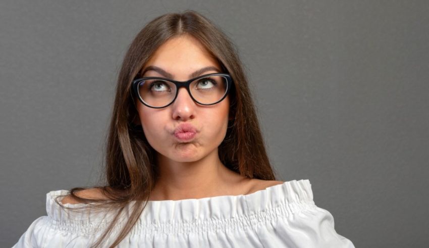 A young woman wearing glasses is making a funny face.