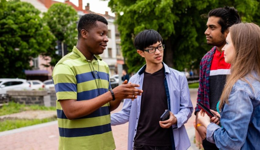 A group of young people talking to each other in a park.