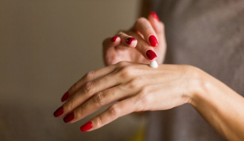 A woman is putting lotion on her hand.