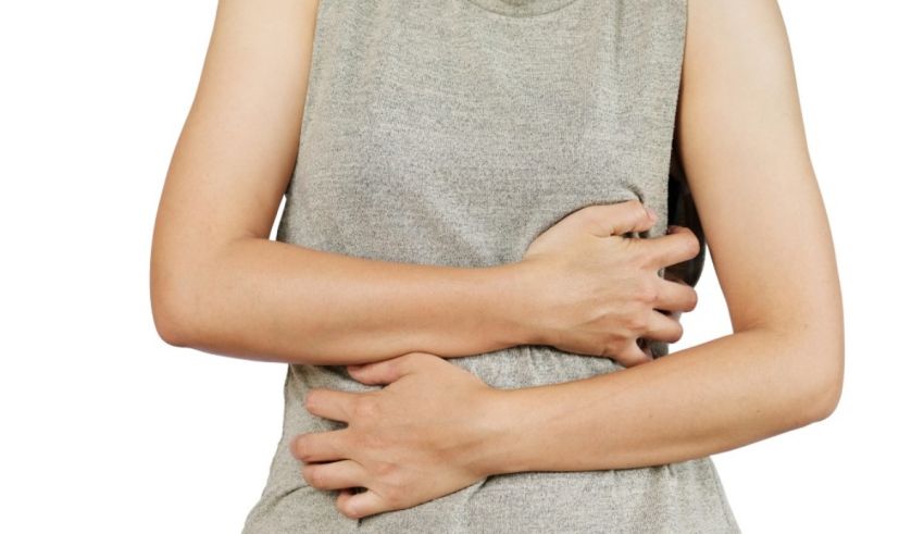 A woman is holding her stomach with her hands.
