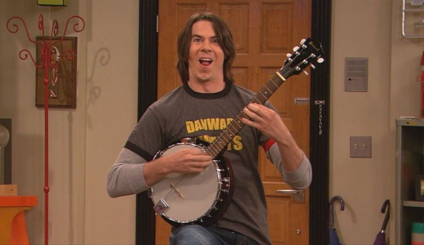 A man playing a banjo in a room.