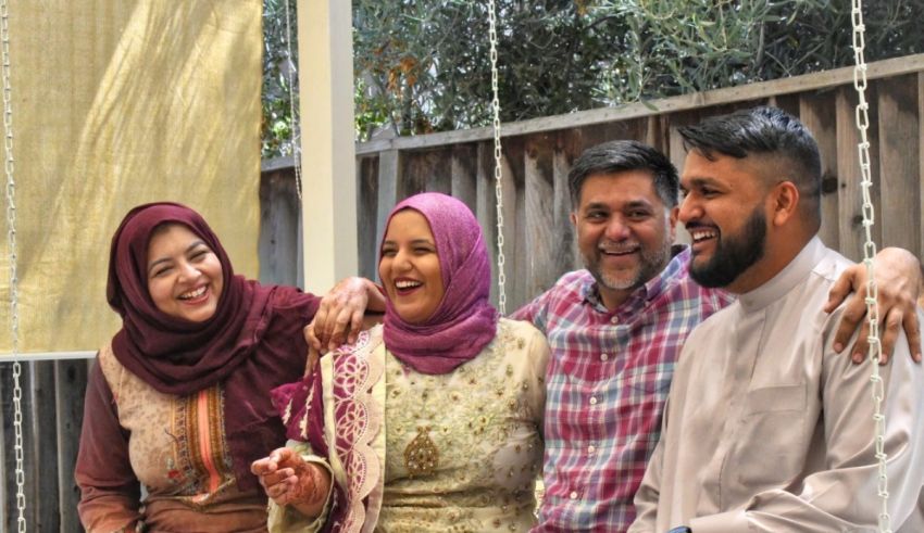 A group of people smiling while sitting on a swing.