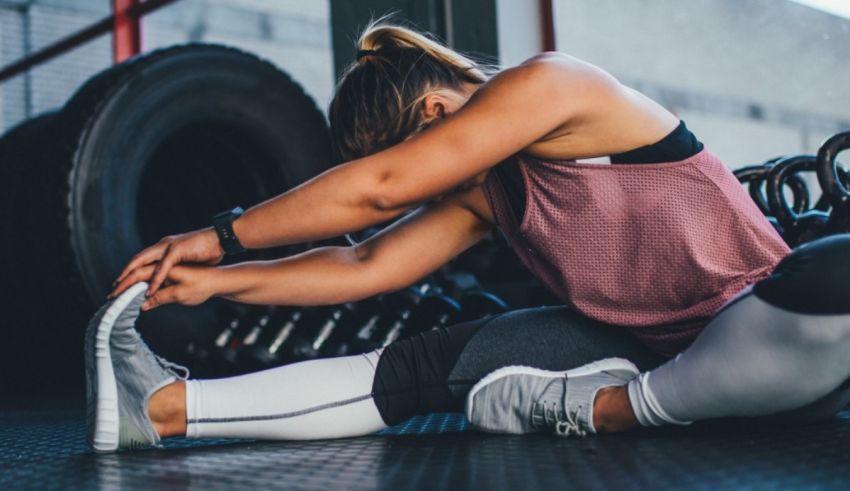 A woman tying her shoes in a gym.