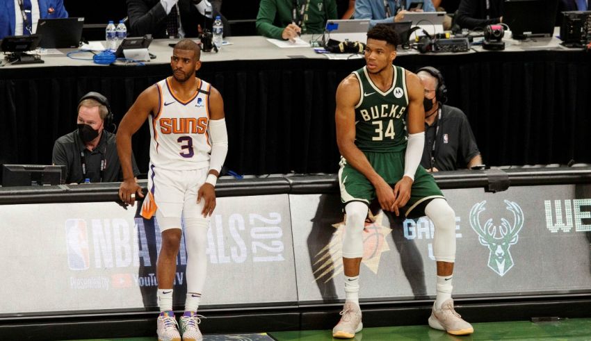 Two basketball players sitting on the bench.