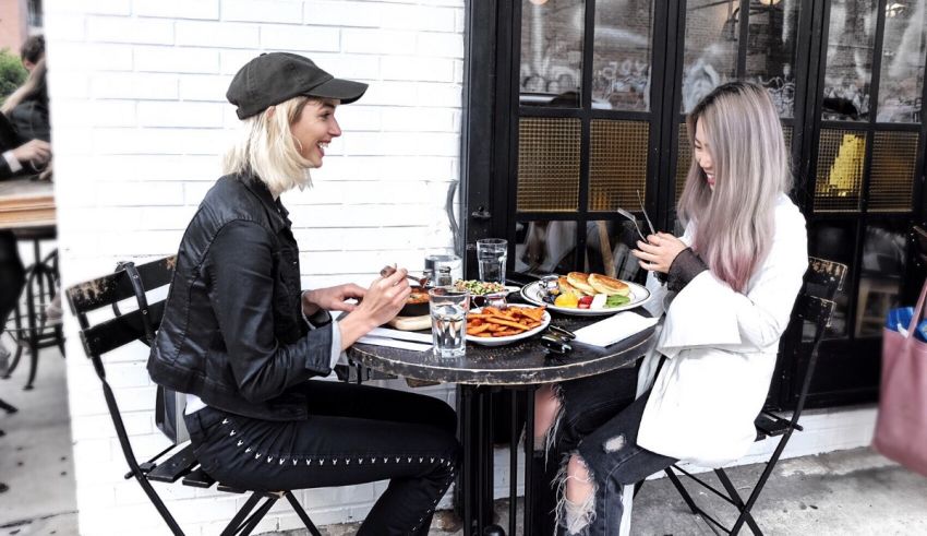 Two women sitting at a table eating food.