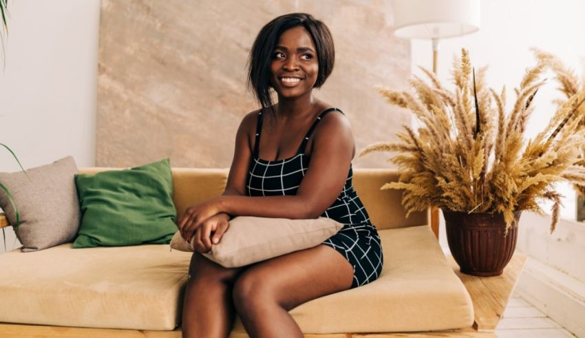 A young black woman sitting on a couch.