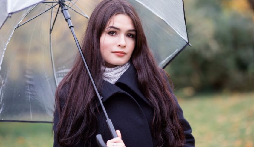 A young woman holding an umbrella in the park.