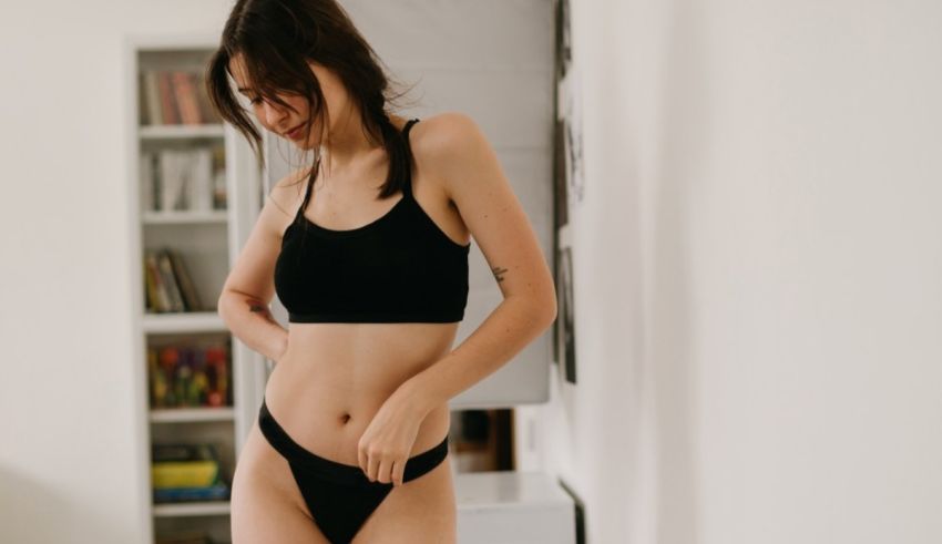 A woman in a black bikini standing in a room.