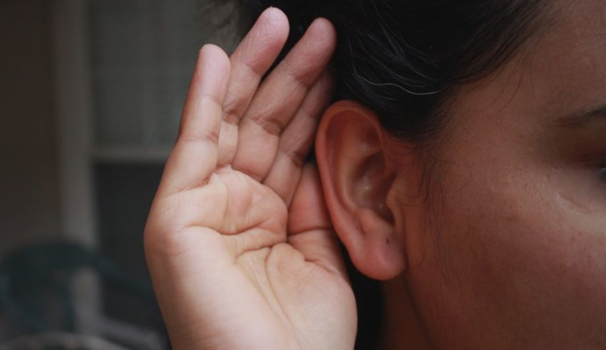 A woman is touching her ear with her hand.