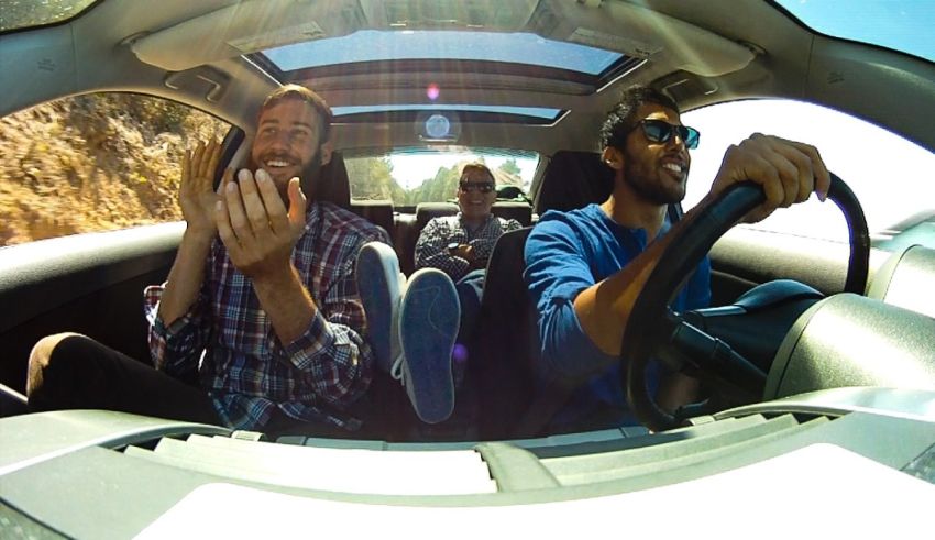 Two men in a car with a camera in the back seat.