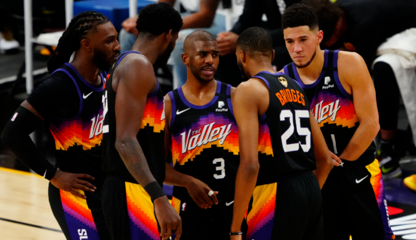 The phoenix suns players are huddled together on the court.