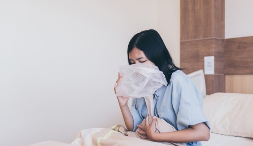 A woman is sitting on a bed with a mask on her face.