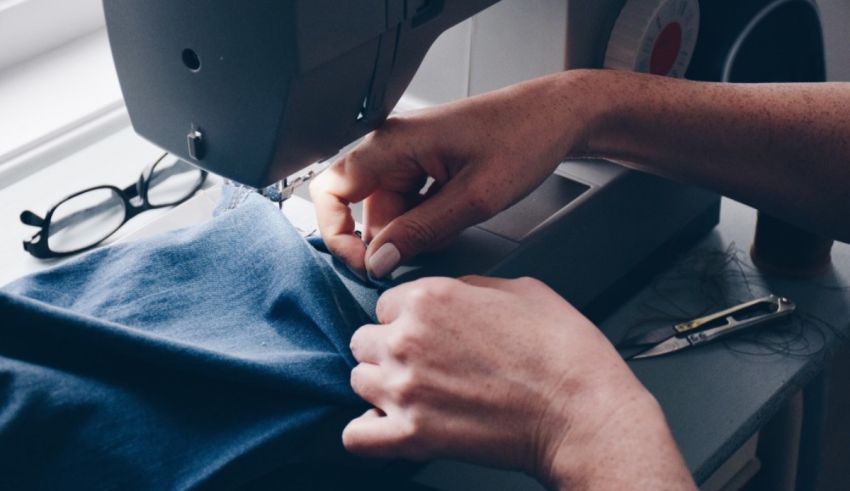 A person using a sewing machine to sew a shirt.