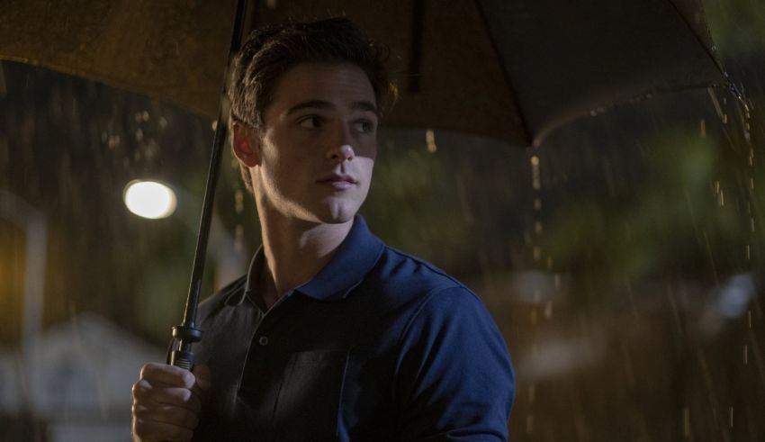 A young man holding an umbrella in the rain.