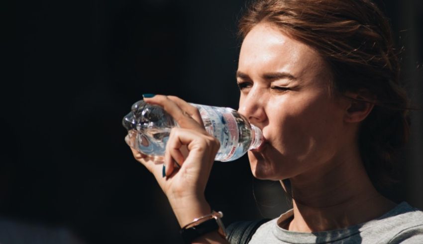 A woman drinking water from a bottle.