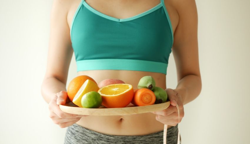 A woman is holding a plate of fruit.