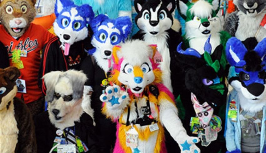 A group of people posing for a photo in a group of stuffed animals.