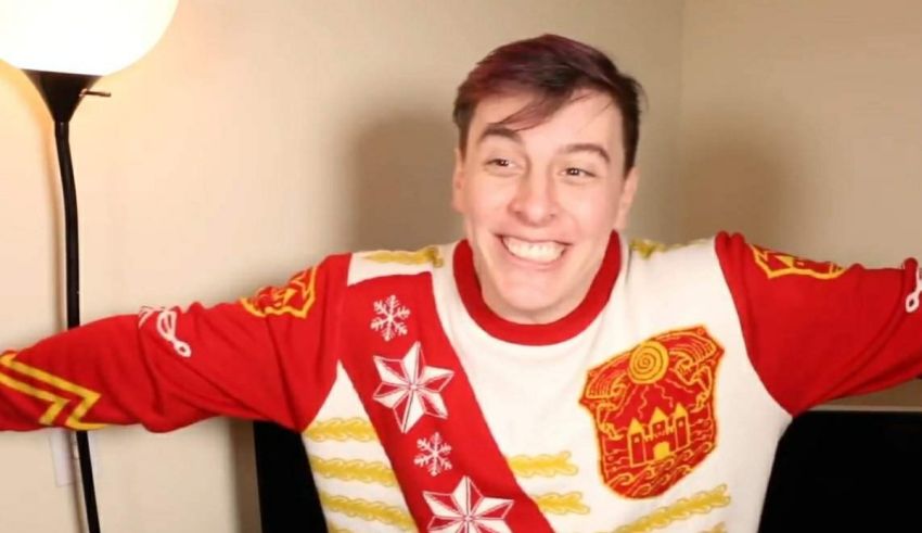 A man in a red and white sweater is posing in front of a lamp.