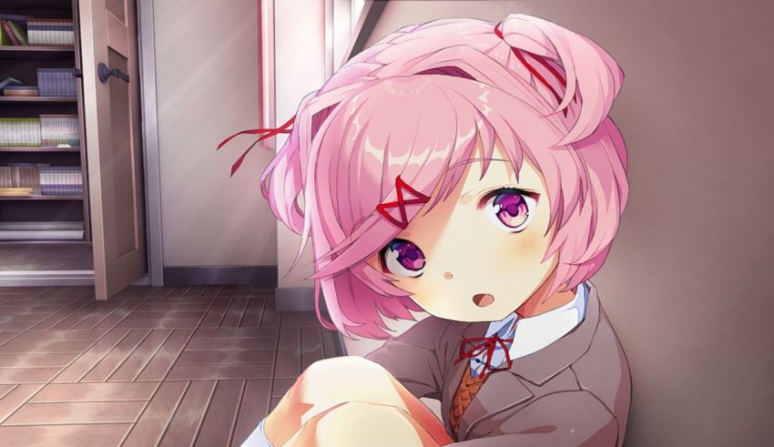 An anime girl with pink hair sitting on the floor.