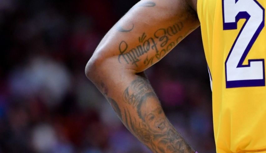 A lakers player with tattoos on his arm.