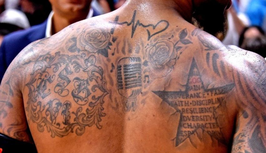 The back of a man with tattoos on his back.