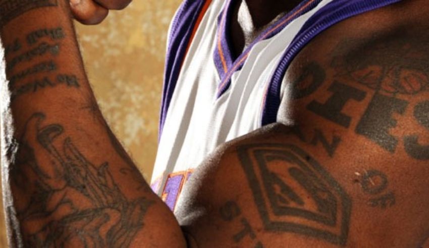 A basketball player with tattoos posing for a photo.
