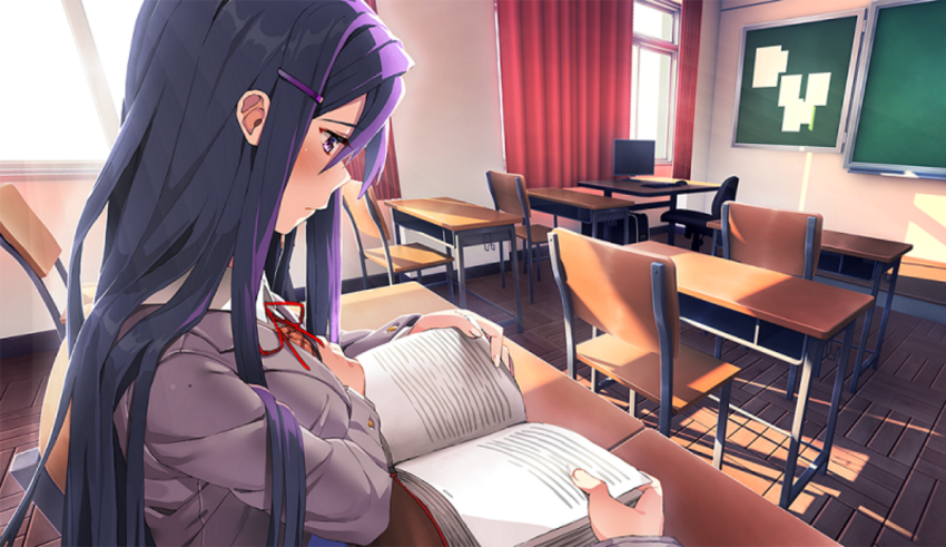 A girl sitting at a desk reading a book.