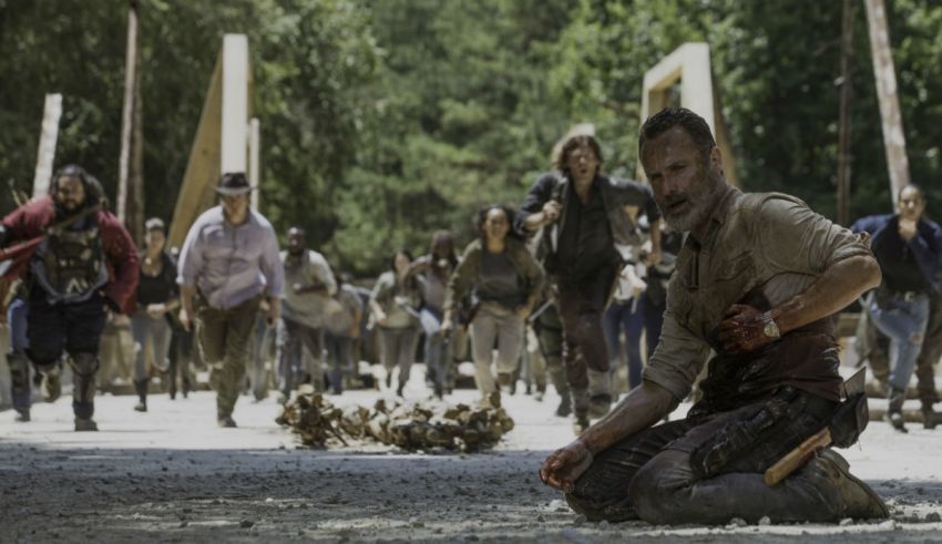 The walking dead - season 7 - a man kneeling on the ground in front of a group of zombies.