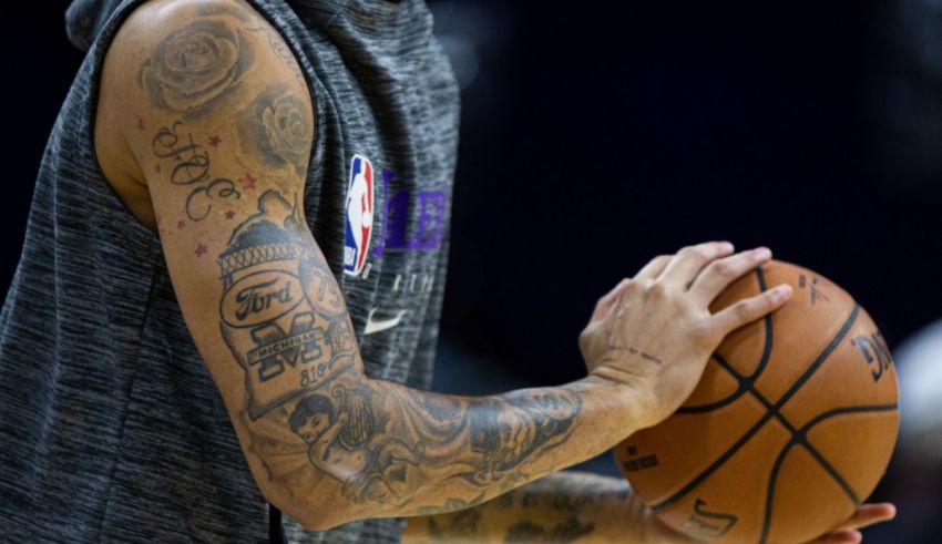 A basketball player with tattoos holding a ball.