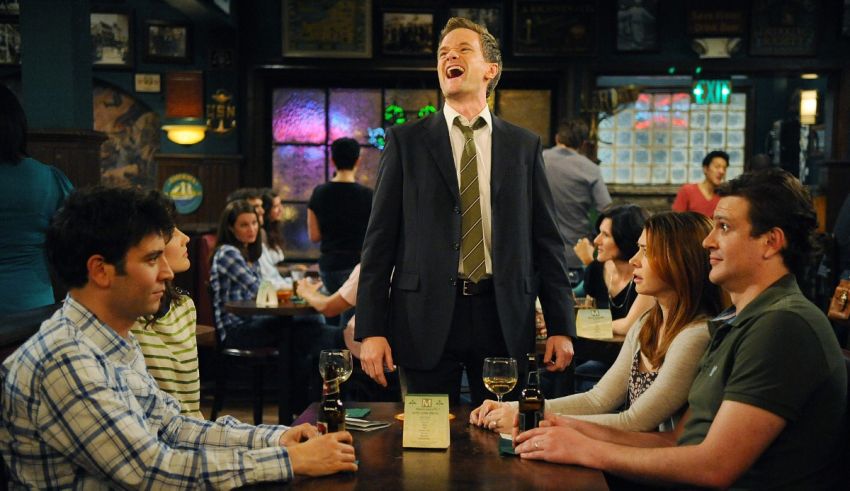 A man in a suit is standing at a bar with a group of people.