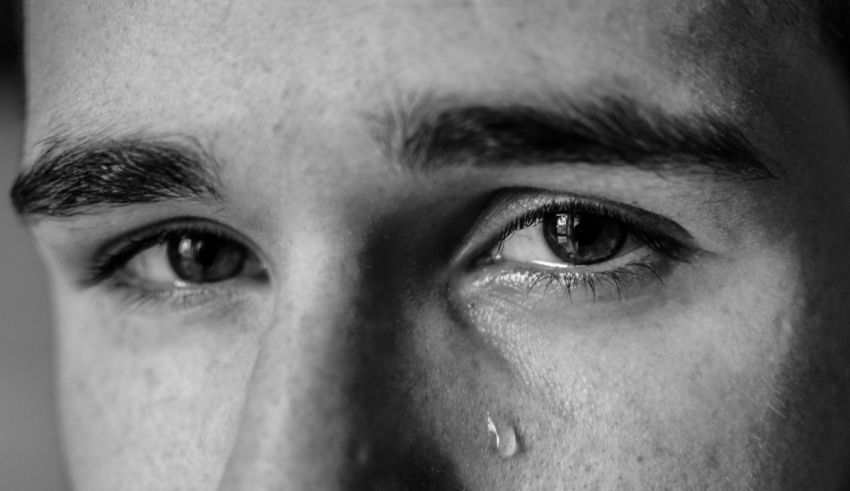 A black and white photo of a man with a tear in his eye.