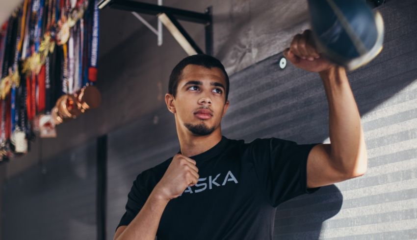 A man in a black shirt is punching a boxing bag.