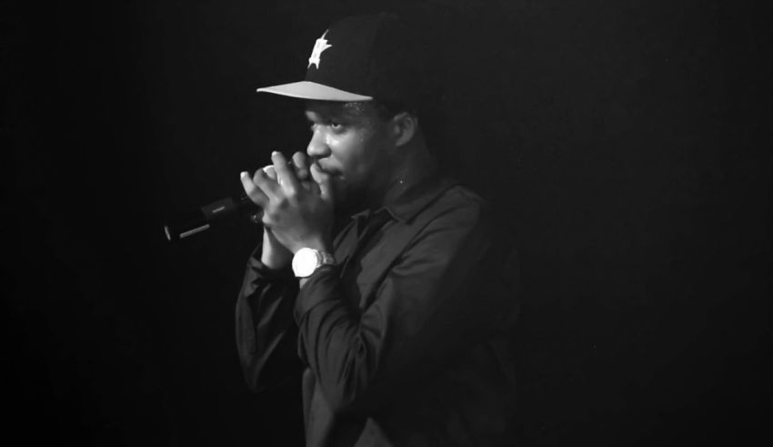 A black and white photo of a man holding a microphone.