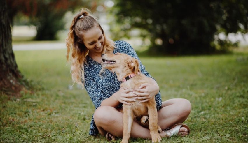 A woman sitting on the ground with her dog.