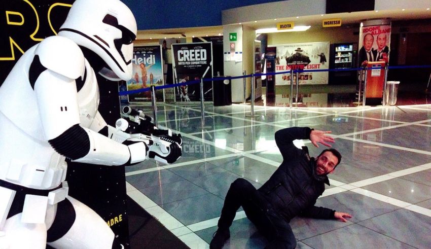 A man laying on the floor next to a stormtrooper.