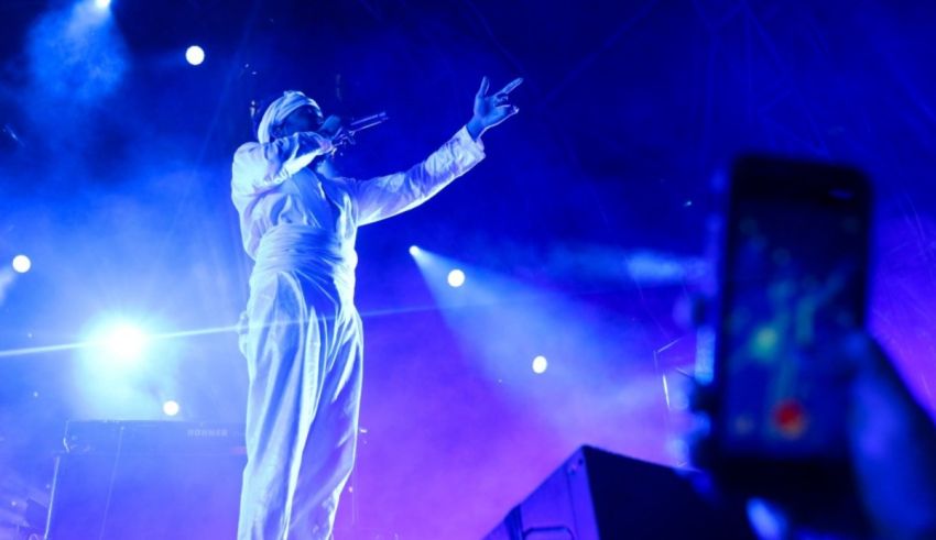 A man in a white shirt is on stage at a concert.