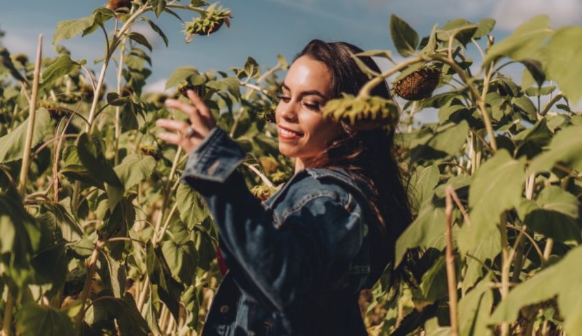 A woman standing in a sunflower field.