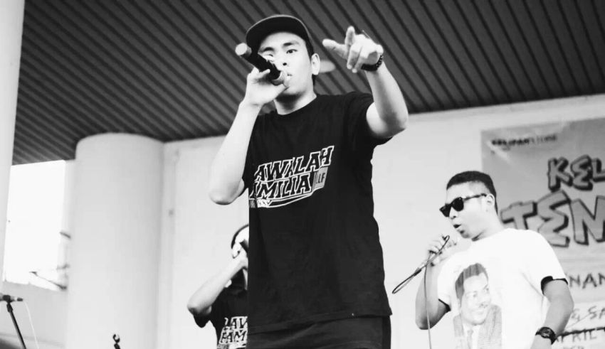 Black and white photo of a man singing into a microphone.