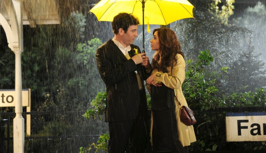 A man and woman standing under a yellow umbrella in the rain.