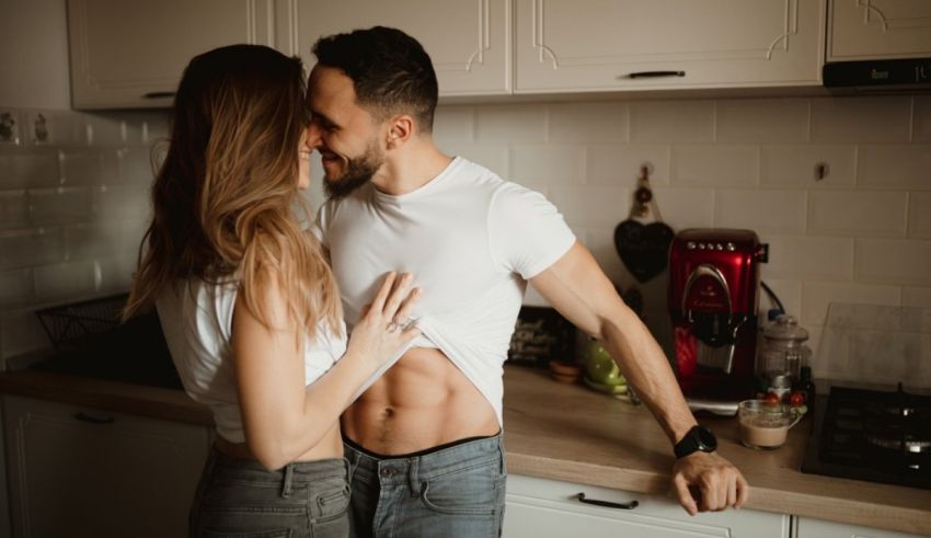 A man and woman hugging in the kitchen.