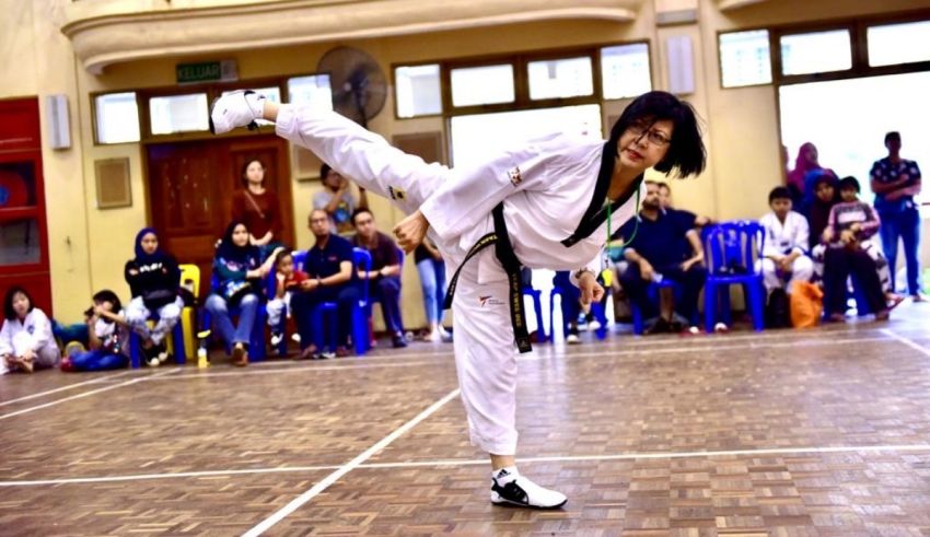 A woman doing a kick in a karate competition.